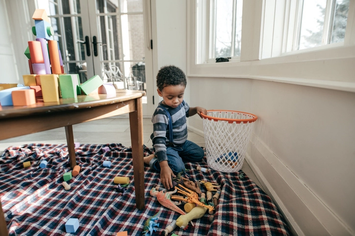 Child cleaning up toys