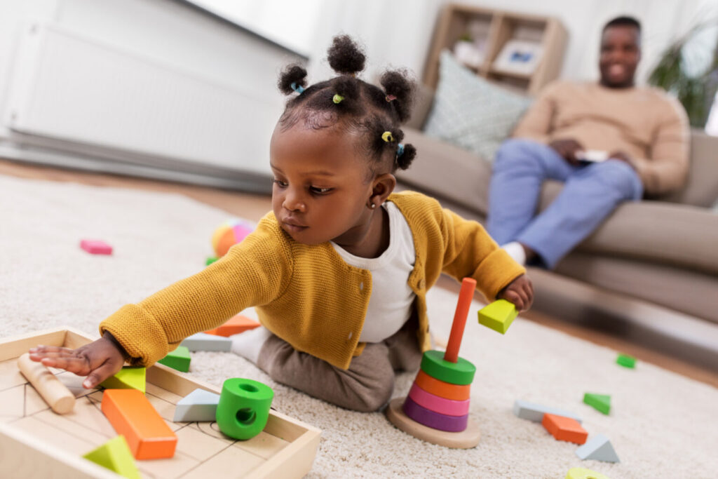 girl playing with toy blocks at home
